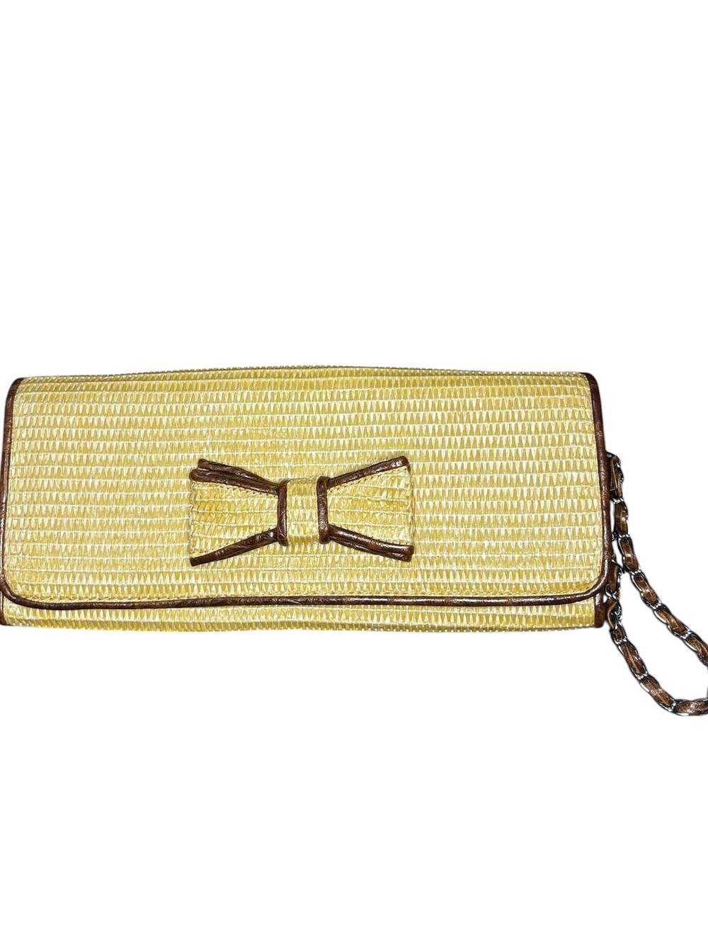 Bueno straw clutch features a distinctive bow detail and matching wristlet strap